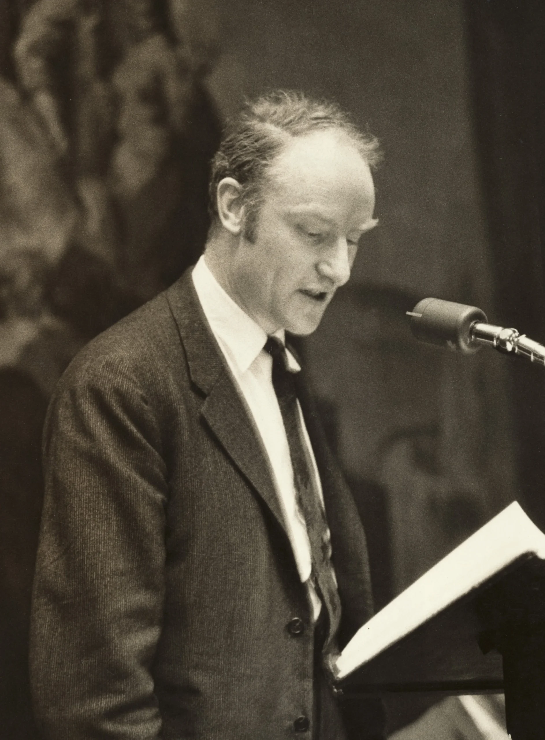 (`snuc-crick.webp`) — Francis Crick(케임브리지 강연). **Wellcome Collection · CC BY 4.0**. src `commons/7/76/Francis_Crick.jpg`. caption: `Francis Crick (1916–2004), lecturing at Cambridge. Having helped draw the structure, he framed the harder question it left open, how the text is read, and named the "central dogma."` (→크릭 인물 page 451 초상 겸용 · 캡션 인물명 → `/authors/crick/` 링크)